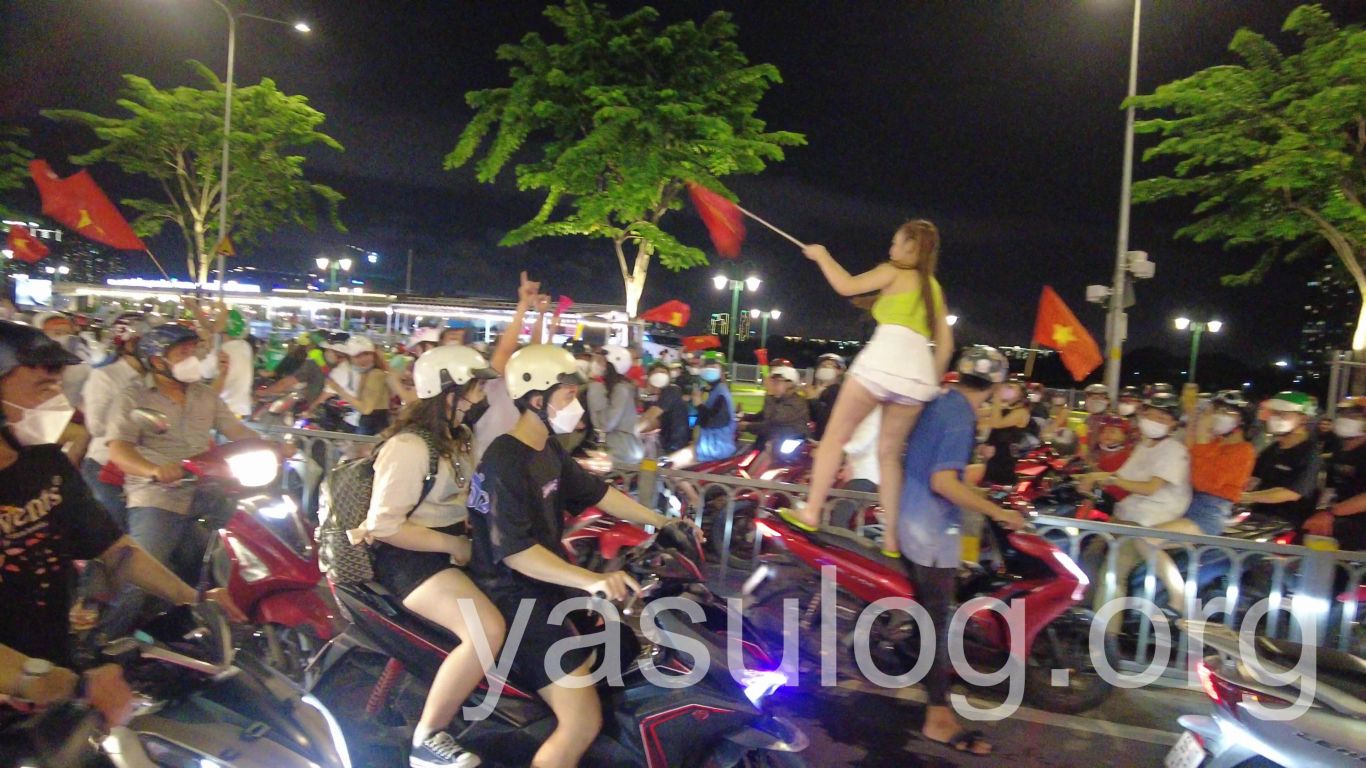 ベトナムのバイクの上で国旗を振る人